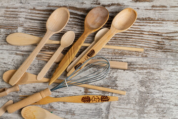 Top view rustic wooden kitchen utensils close up. Spoons and whisk.