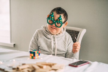 elderly woman with Down syndrome in funny Christmas glasses with a garland in hands