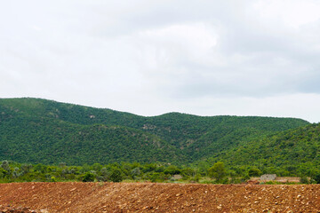 Green mountains with white cloudy sky background.