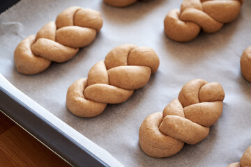 Raw dough braided bread rolls made from whole grain spelt flour, before baking