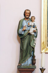 Saint Joseph holds the child Jesus, statue at the altar of Saint Anne in the parish church of Wounded Jesus in Gradec, Croatia - 552086769