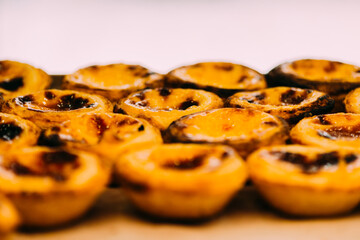 Stack of Portuguese egg tart also known as Pasteis de Nata on display in front of shop
