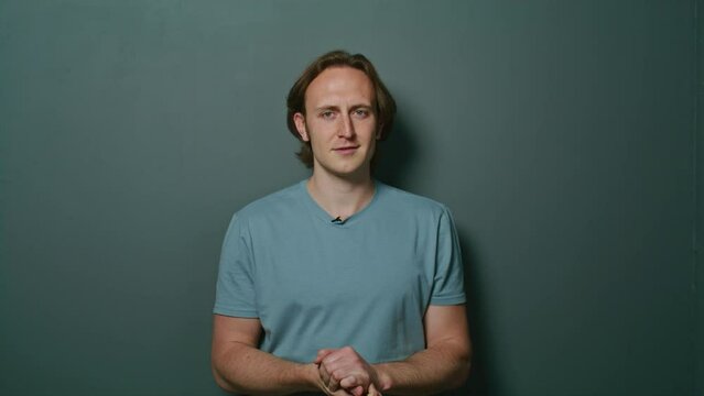 portrait of an artistic young man speaking on camera, actor smiling, talking, gesticulating, laughing.charming young man gives a speech.