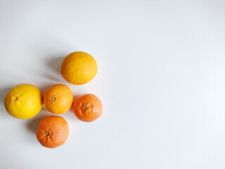 Oranges and tangerines on white background. Top view, flat lay. Autumnal first fruits and seasonal concept.