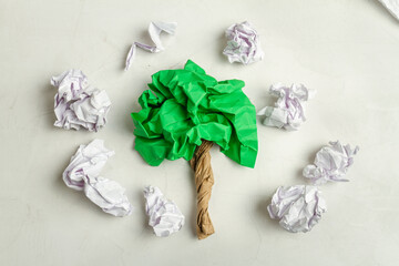 Fototapeta na wymiar Top view of green crumpled paper in shape of tree. Enviroment pollution concept.