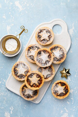 Traditional Christmas dessert with dried fruits - mince pies on a blue background. Top view © Olga Romankova