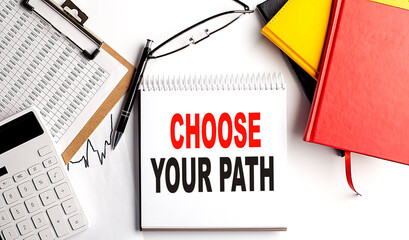 CHOOSE YOUR PATH text on notebook with clipboard and calculator on white background