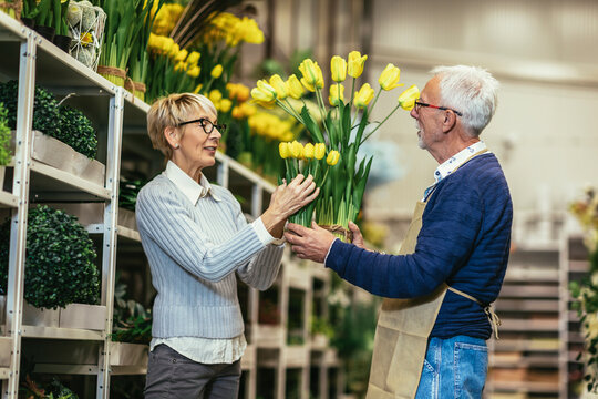 Senior woman buying flowers at the local flower shop.