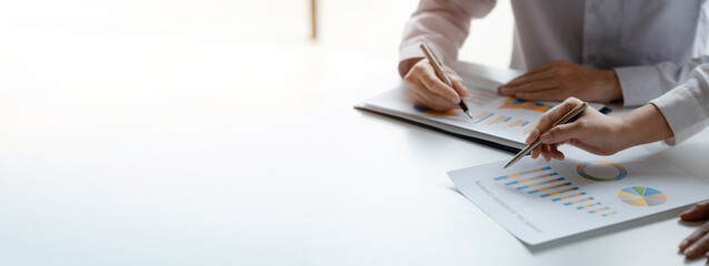 Two businessmen pointed to the material for the meeting, working together to plan to develop and solve common business problems. Concept of business management for growth and quality.