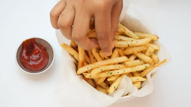 top view of hand pick fresh fries from a bowl on white background 