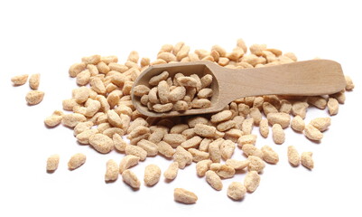 Extruded crunchy oat flakes, pile in wooden spoon, isolated on white