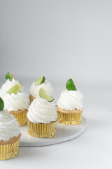 Lime cupcakes on a plate, lime cupcake with white buttercream and a a lime wedge, margarita cupcake