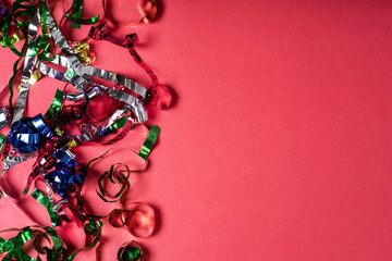 Bright colorful confetti sparkles on a pink background, the theme of a holiday and a birthday.