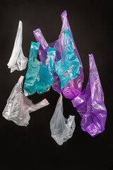 Vertical shot collection of colorful plastic bags. Isolated on black background.