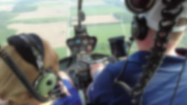 Blurred Woman Enjoying Private Helicopter Tour In Cockpit As Pilot Flies Helicopter