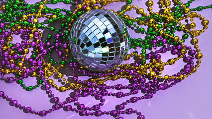 Mardi Gras background with purple, green, yellow beads and disco ball