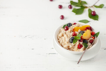 Oatmeal cereal with berries in a bowl on the table. A healthy breakfast. Baby food.