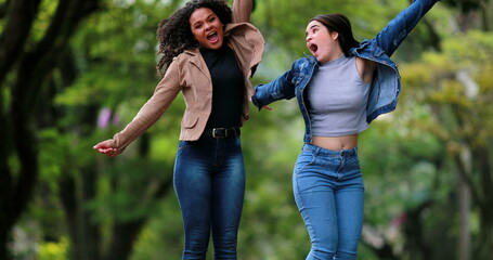 Two women jumping in the air with joy and excitement