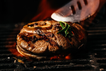 Beef steaks pieces of meat on the grill with flames. American cuisine. The concept cooking meat. Food recipe background. Close up. place for text