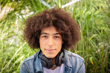 Portrait of a smiling handsome young mixed race afro italian teenager with thick curly hair...