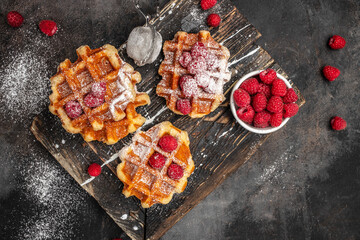 Belgian waffles with raspberries with sugar powder in a freeze motion of a cloud of powder midair, served with jug of milk. Delicious breakfast or snack. Long banner format