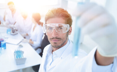 tube with reagents on blurred background laboratory.
