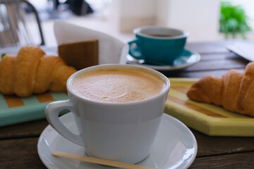mug of coffee and croissants, coffee break on defocused background