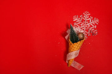 Ice Cream Cone with Christmas Decoration on red background. Minimal Christmas Concept. Flat Lay