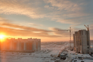 Construction of multi-storey residential buildings at dawn in winter