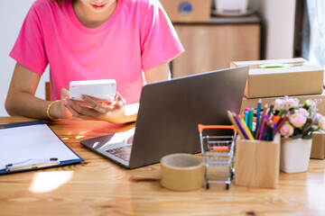 Fototapeta na wymiar Startup Freelance Small Business Entrepreneur, young Asian woman portrait in pink dress working at home, box, smartphone, laptop, online, marketing, packaging, delivery, SME. , ecommerce concept