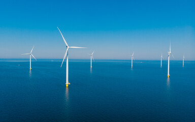 Windmill turbines at sea view from a drone aerial view from above at a huge windmill park with a...