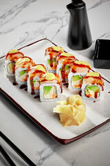 Sushi rolls with cream cheese, avocado, masago, butterfish, mayonnaise and unagi sauce