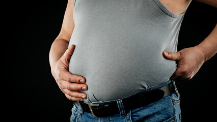 a fat man checking his weight on a black background.