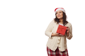 Isolated portrait on white background, pretty woman wearing Santa hat, posing with gift box with cute present for Christmas. Copy advertising space. Boxing Day. Christmastime. New Year's preparations