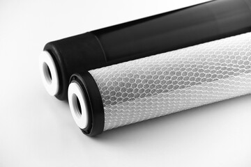 two filter cartridges for house water filtration system isolated. Granular and briquettes carbon...