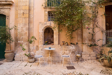 Terrace with table and chairs near aged building