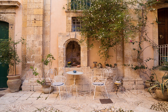Terrace with table and chairs near aged building
