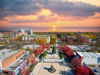 an aerial shot of the Decatur Square with a Christmas tree, red and yellow autumn trees, lush green...