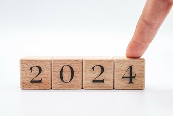 Hand choosing the number 2024 in wooden block cubes isolated on a white background. new year concept