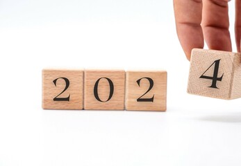 Hand choosing the number 2024 in wooden block cubes isolated on a white background. new year concept