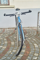 Fototapeta na wymiar A bicycle with a crooked front wheel standing on a paved sidewalk. High quality photo