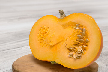 cut pumpkin with seeds on a wooden board, healthy foods