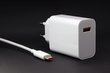 Charger with USB connector, cable with type-c connector on a dark background. Mobile Phone Charger