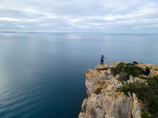 Fototapeta na wymiar Person on cliff standing looking towards the horizon.