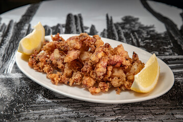 Crispy baby squid with lemon served on a plate