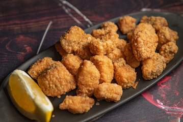Crispy homemade nuggets with a slice of lemon on a plate