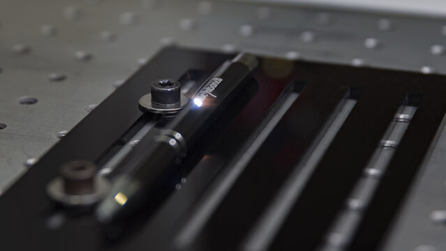 Close-up laser engraving action on a black pen