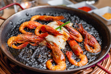Paella with prawns and black rice