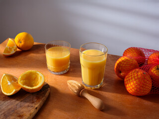 A glass of freshly pressed orange juice on the kitchen counter. Morning atmosphere, sunlight