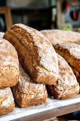 Loaves of bread on the shelves of the shop bakery counter. Fresh, homemade wheat and whole grain breads and pastries.